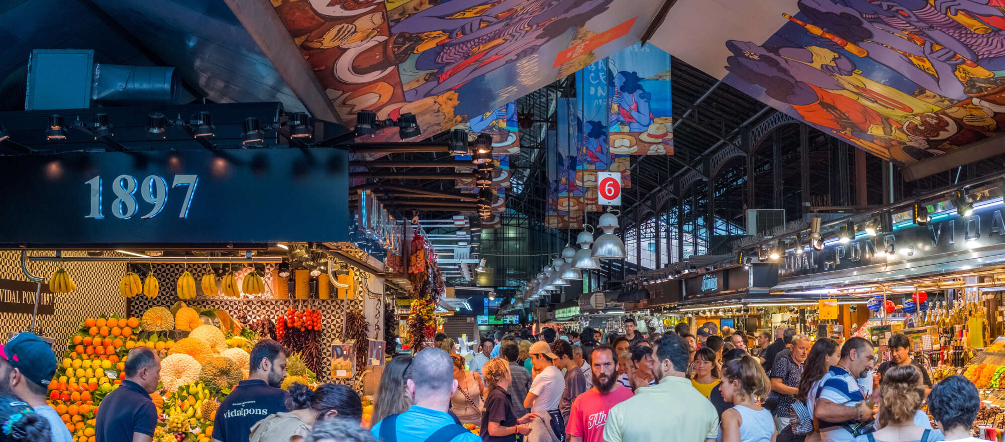Famous La Boqueria market is filled with people and with an assortment of Spanish foods.