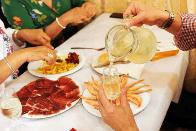 Jug of "rebujito", Iberian ham, and prawns being eaten in a "caseta" at the April Fair, Fair of Seville, Andalusia, Spain.