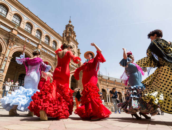 Young women dance flamenco on Plaza de España during the famous Feria festival.