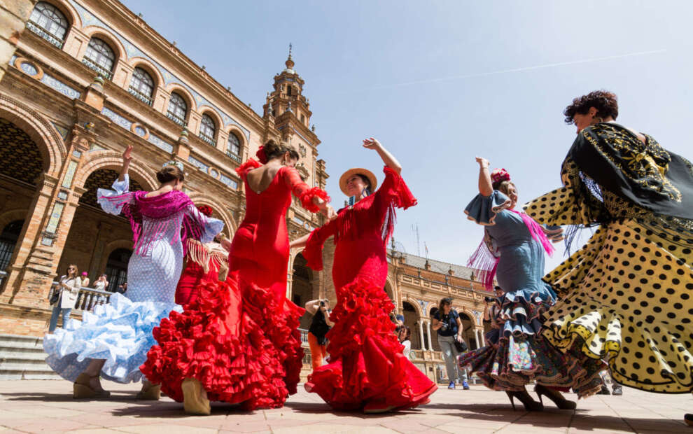 Young women dance flamenco on Plaza de España during the famous Feria festival.