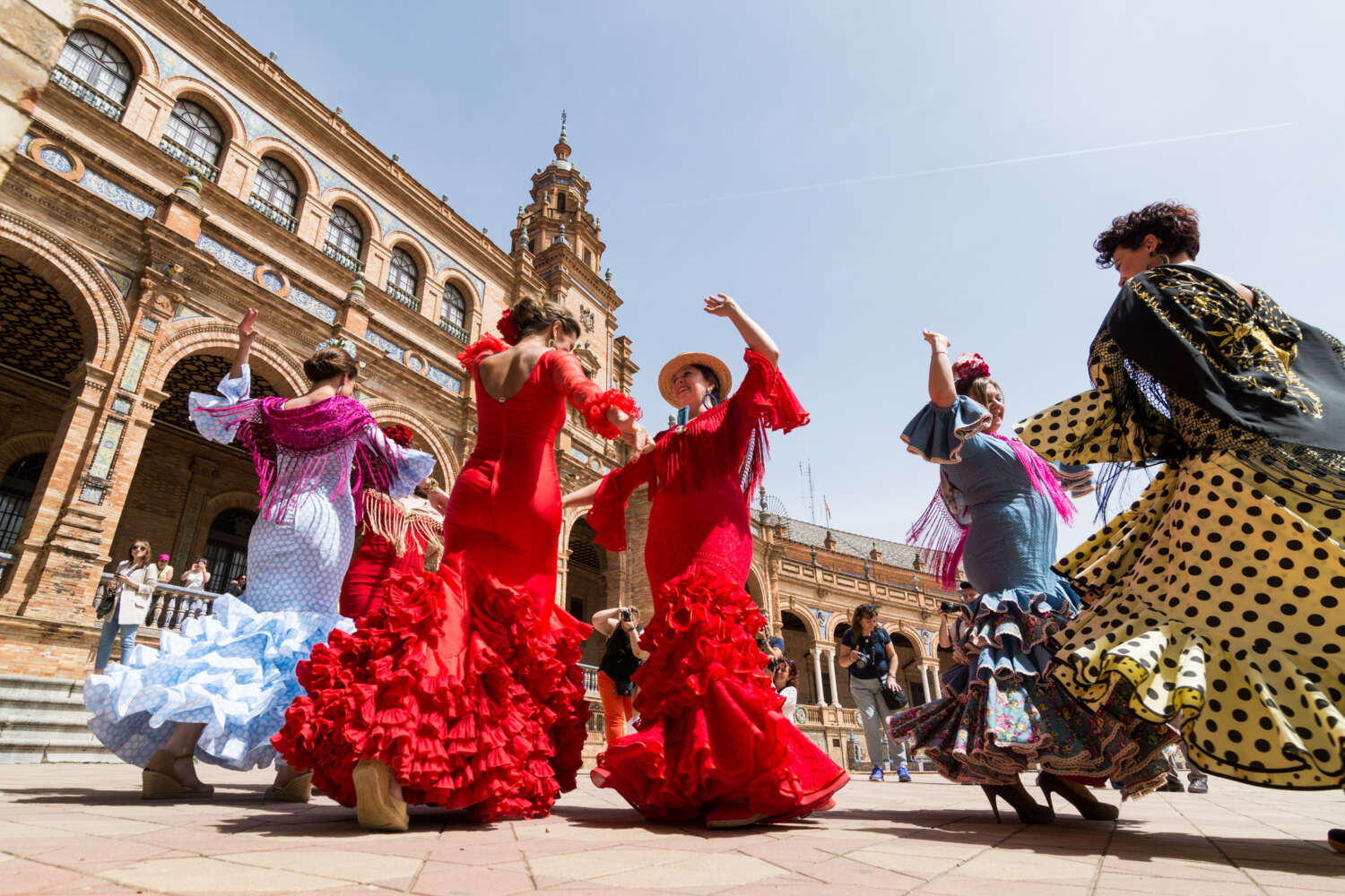 Young women dance flamenco on Plaza de España during the famous Feria festival.