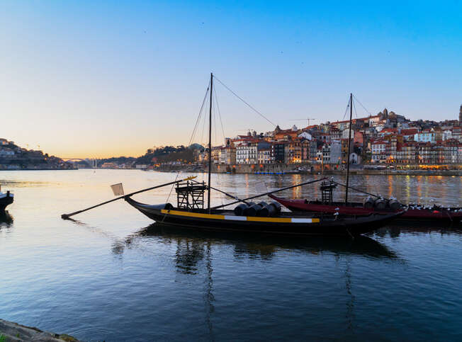 Picturesque, colorful view of the old town of Porto at sunset over the Douro River.